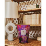 Baobab Collection candela Arty Flowers Ninfea formato MAX 10 ambientata su libreria, tonalità viola e fucsia floreali MAX10AFLI