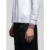 D1 Milano Polycarbon Electric Clash orologio indossato al polso, quadrante arancione e cassa viola con dettagli geometrici PCBU22