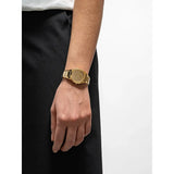 D1 Milano Ultra Thin Gold Gleam orologio indossato su polso donna, bracciale acciaio dorato lucido design minimal UTBL40