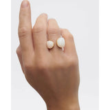 Pdpaola Anello Quartz Gravity indossato su mano, due quarzi bianchi cabochon su montatura dorata AN01-D40-08