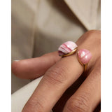 Pdpaola Anello Spring Rhodochrosite Gravity indossato su mano, dettaglio pietre rodocrosite rosa e montatura oro AN01-E99-08
