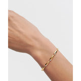 Pdpaola Bracciale Caramelle dettaglio indossato su polso, maglie curve dorate con zirconi cubici a castone PU01-932-S