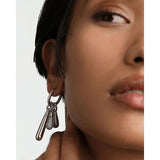 Pdpaola Icons Drop Silver dettaglio orecchino con ciondoli a goccia lisci e pavé di cristalli, vista indossata CO02-789-U