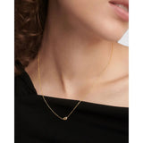 Pdpaola Collana Essentials 2026 Delta indossata su abito nero, catena dorata con pendente e zircone CO01-873-U