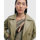 Pdpaola Collana Orbit Cord indossata con trench in pelle, choker dorato e cordino nero con terminali a goccia CO01-A18-U