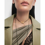 Pdpaola Collana Orbit Cord dettaglio ravvicinato elemento curvo placcato oro 18kt su cordino nero indossata CO01-A18-U