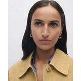 Pdpaola Orecchini Essentials 2026 Loop indossati su modella, vista frontale con entrambi gli orecchini dorati AR01-C85-U