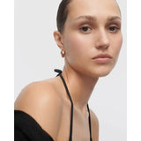 Pdpaola Orecchini Volcano indossati da modella, orecchino a cerchio bombato oro su look contemporaneo AR01-C29-U