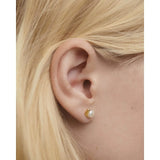 Pdpaola Orecchini La Perla Mini Stud dettaglio indossato su lobo con perla d'acqua dolce e montatura dorata AR01-E61-U