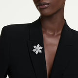 Swarovski Idyllia Snowflake indossata come spilla su blazer nero, motivo fiocco di neve cristalli bianchi 5754685