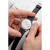 Vulcain Grand Prix Silver vista indossata tra le mani, quadrante argento e cinturino pelle nera liscia 670171A50.BAN249