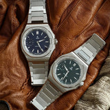 Yema Wristmaster Slim Small Seconds CMM.29 blu e nero affiancati su guanto in pelle marrone 76.26.29.05.SN.M